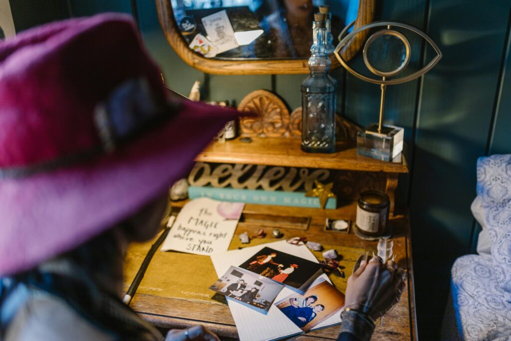 A mystical desk setup with crystals, vintage photographs, and a 'Believe' sign, evoking a sense of magic.